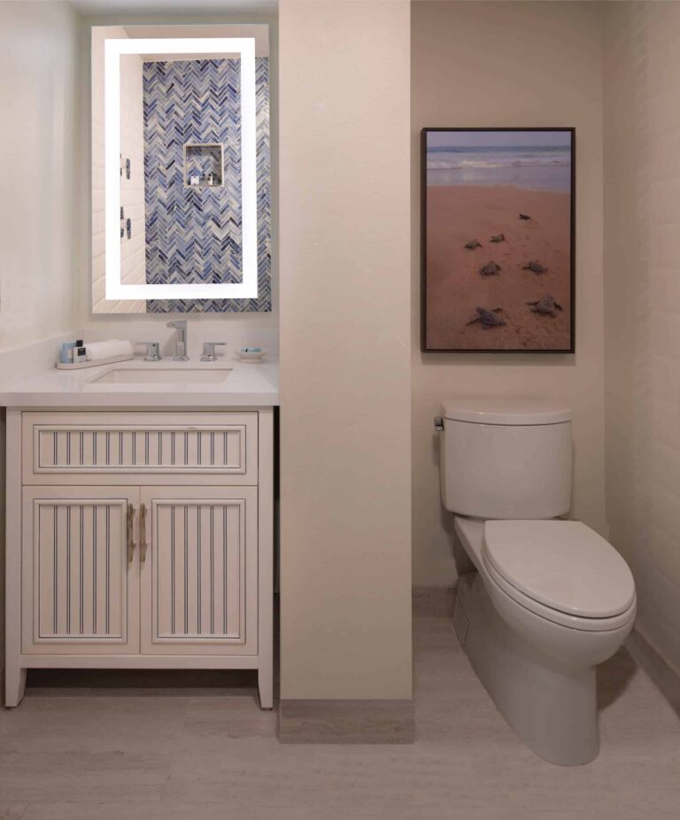 Junior 1-bedroom suite bathroom with sink, mirror, and toilet