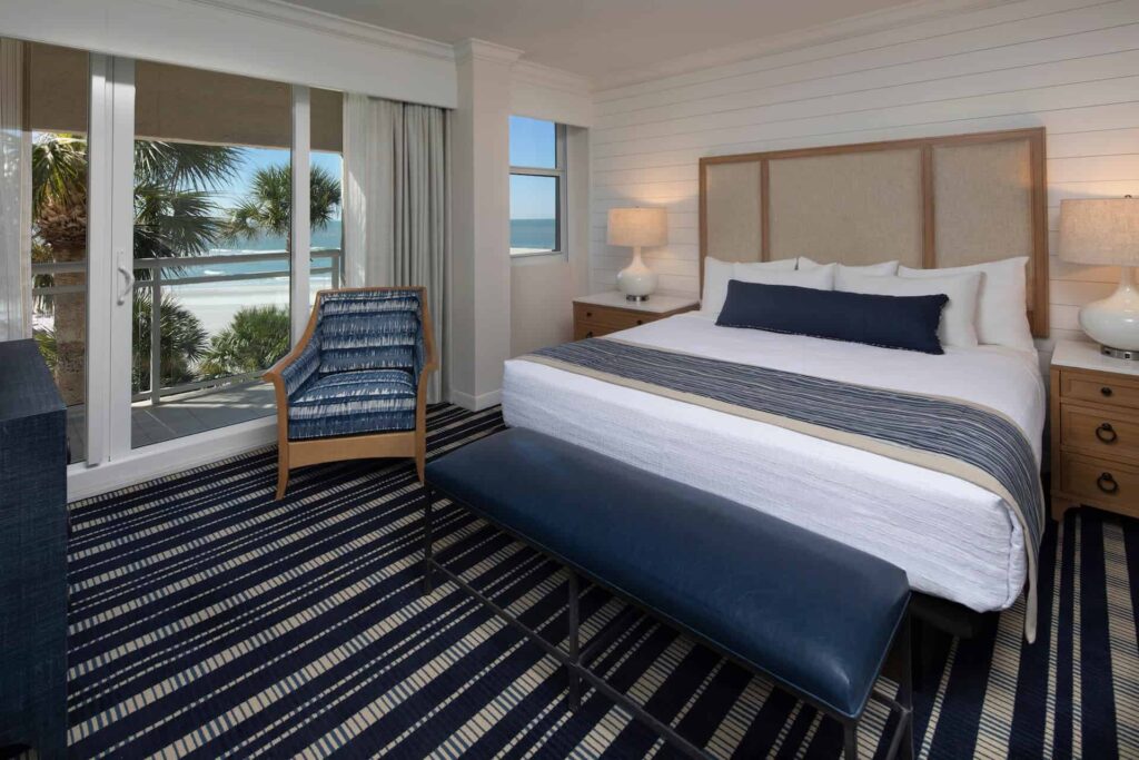 Dormitorio en suite con cama King, vista a la playa y acceso al balcón