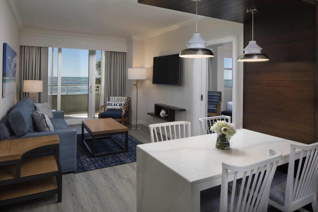 Sala de estar de la suite Junior de 1 dormitorio con acceso al balcón y vista a la playa