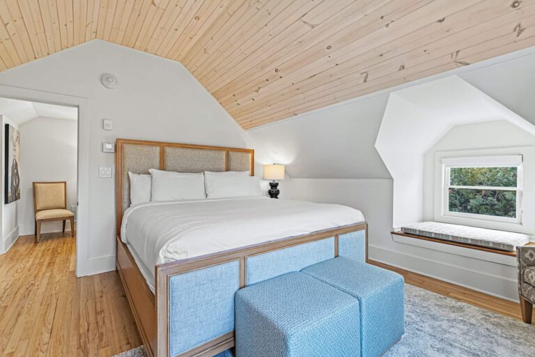 Dormitorio estilo loft de First House con techos abovedados