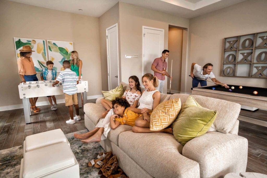 Familia jugando y viendo televisión en el desván de una residencia de Spectrum Resort.
