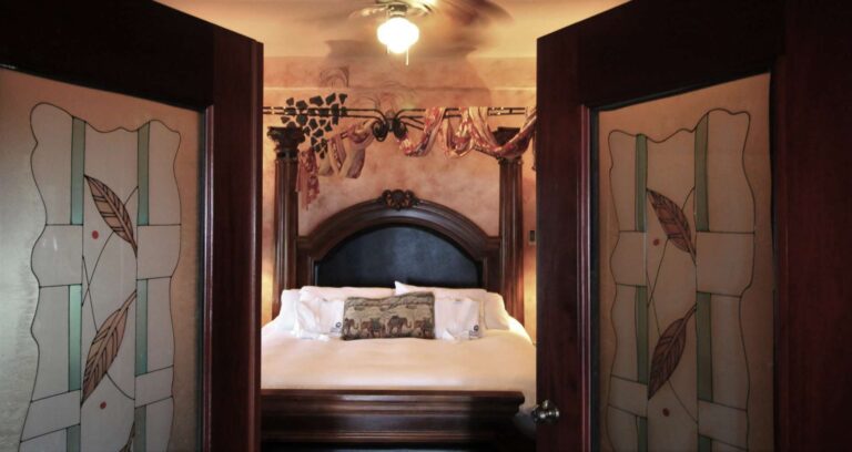 Honeymoon Suite stained glass French doors opening to four poster bed