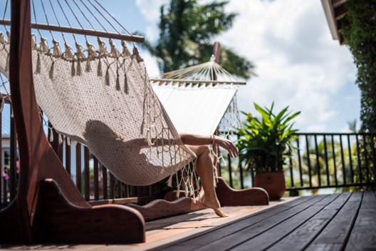 Woman lying in a hammock at a Seafront Vista Villa overlooking the beach