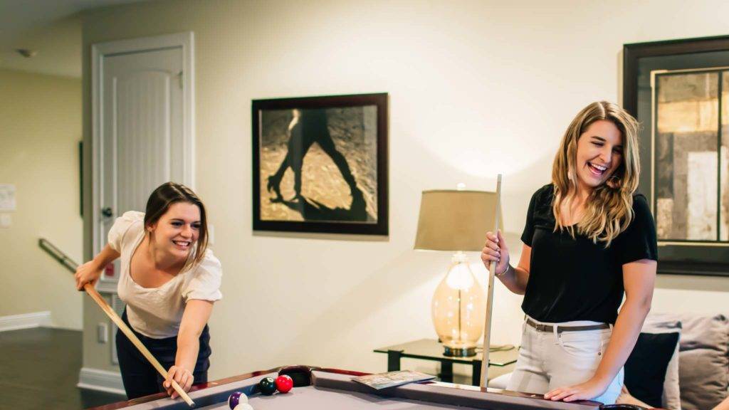 两个女人在她们的房间里打台球 Encore Resort 在 Reunion 度假屋。