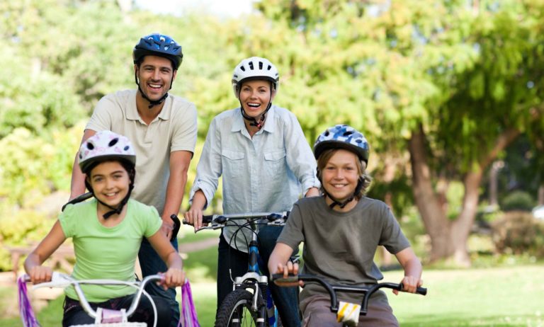 Mama, Papa und Kinder fahren zusammen Fahrrad.