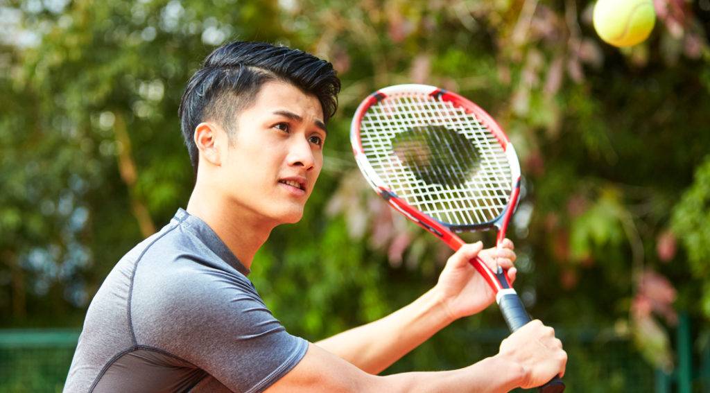Hombre golpeando una pelota de tenis con una raqueta en Rentyl Resorts orlando