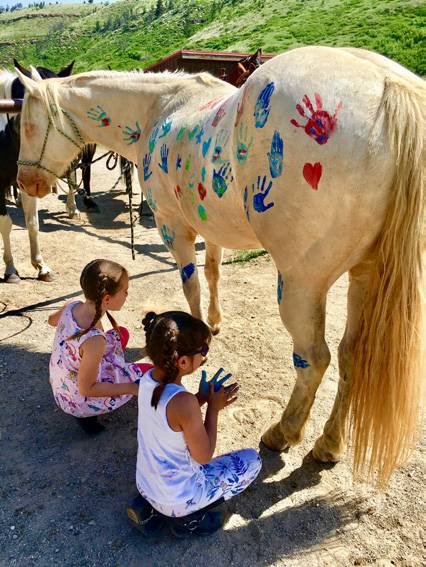 Kids Petting A Horse With Painted Hand Prints At The Ranches At Belt Creek.