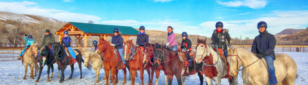 Gruppe zu Pferd auf den Ranches am Belt Creek bei einem verschneiten Winterausflug.