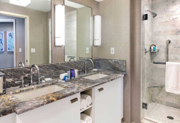 2 Bedroom Residence bathroom with double sink and walk-in shower