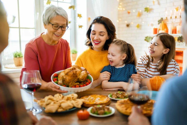 Happy family gathered around a table for Thanksgiving dinner.