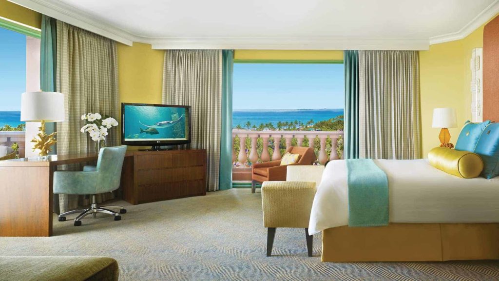 El dormitorio de la Royal Regal Suite con balcón con vista al mar y al puerto