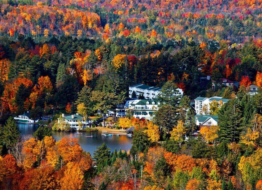 Aerial view of the Mirror Lake Inn surrounded by trees with colorful fall foliage.