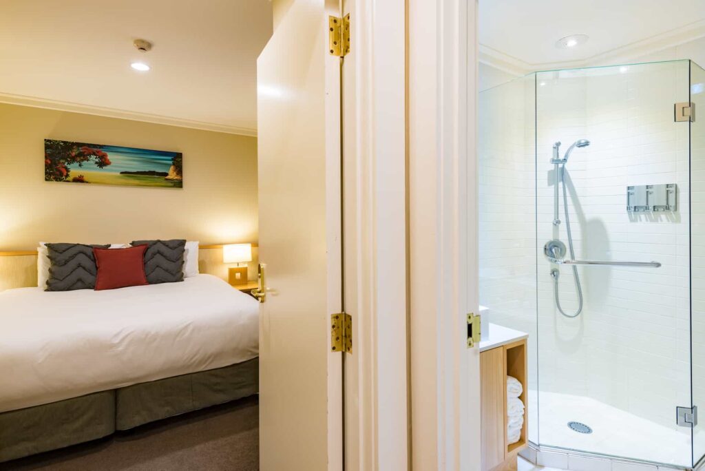 Baño del apartamento ejecutivo de dos dormitorios con ducha con mampara de cristal