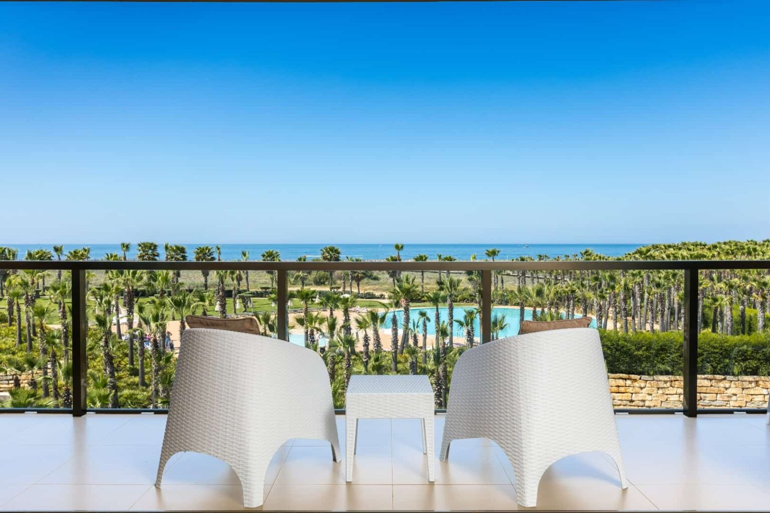 Junior Suite balcony with sea view, chairs, and coffee table