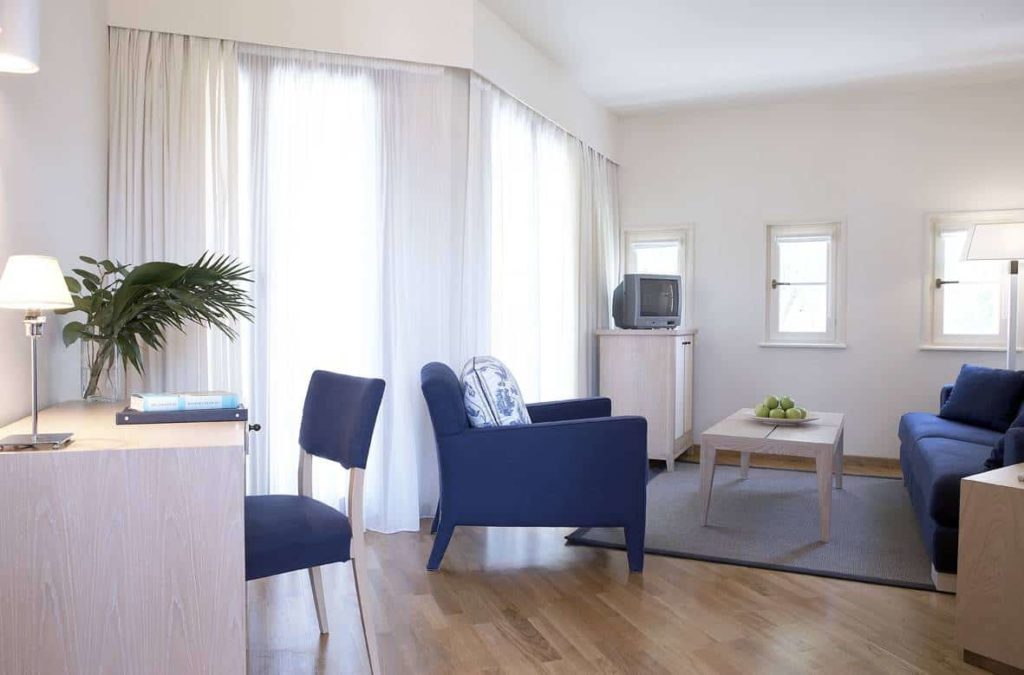 Wohnbereich der Deluxe Suite mit Schreibtisch, Sofa, Sessel und TV