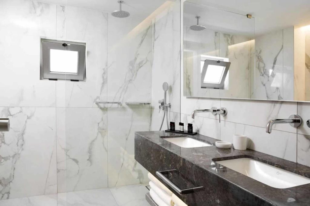 Exklusives Bungalow-Badezimmer mit Marmorwaschbecken und ebenerdiger Dusche