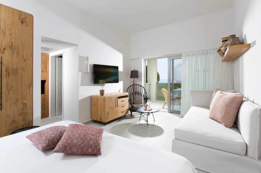 Exclusivo dormitorio tipo bungalow con cama king, sofá cama y televisor colgado en la pared