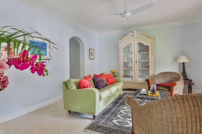 Sala de estar amueblada con lujoso sofá y cojines: Suite Cap Cove de 2 dormitorios