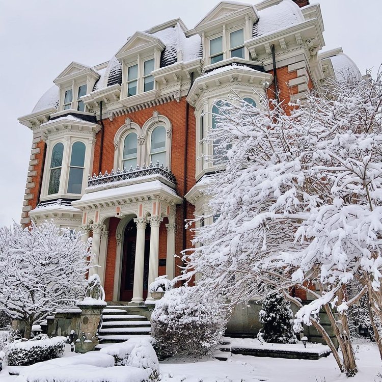 The Mansion on Delaware Avenue front entrance covered in snow in winter.