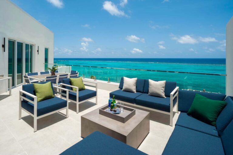Spacious oceanfront balcony with outdoor lounge seating: 3 Bedroom Penthouse at Rum Point Club