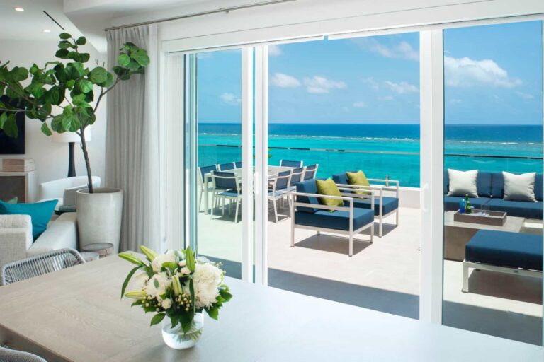 Dining room with oceanfront balcony access: 3 Bedroom Penthouse at Rum Point Club