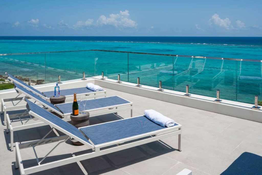 Beach chairs on outdoor balcony overlooking the ocean: 4 Bedroom Penthouse at Rum Point Club