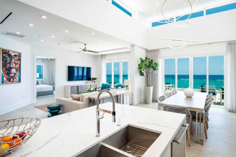 Kitchen, dining, and living room with ocean view: 4 Bedroom Penthouse at Rum Point Club