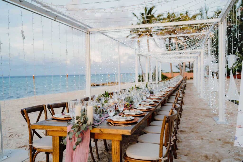 Long table on the beach set for a wedding at Rum Point Club.