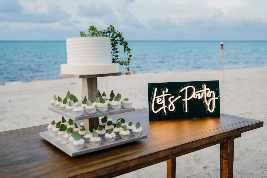 Wedding cake and cupcakes for guests on the beach at Rum Point Club.