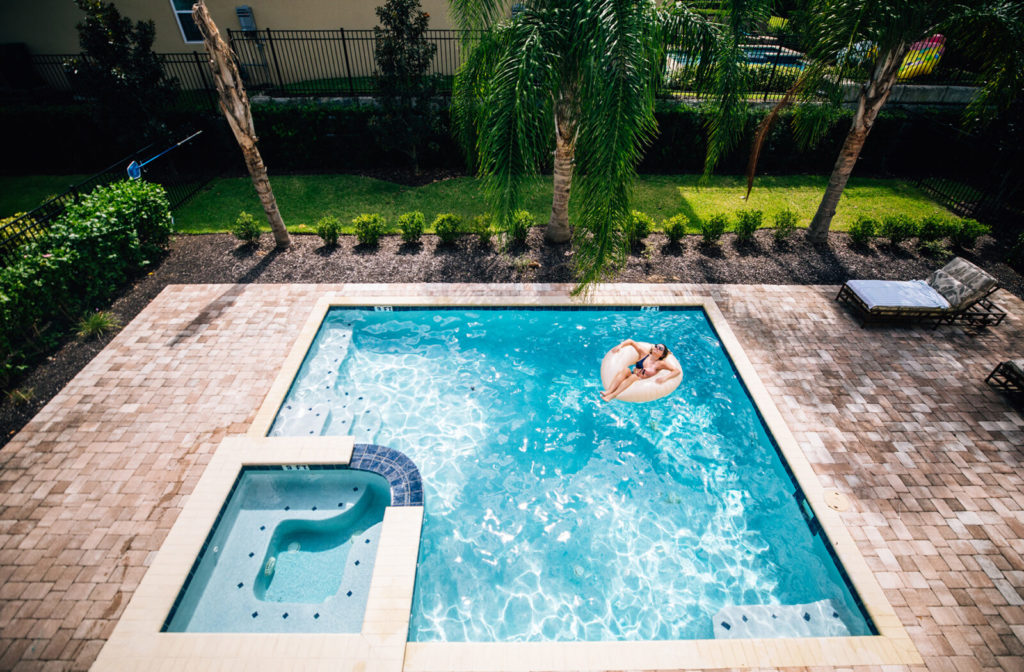 Woman relaxing in a pool float in a private vacation home pool.