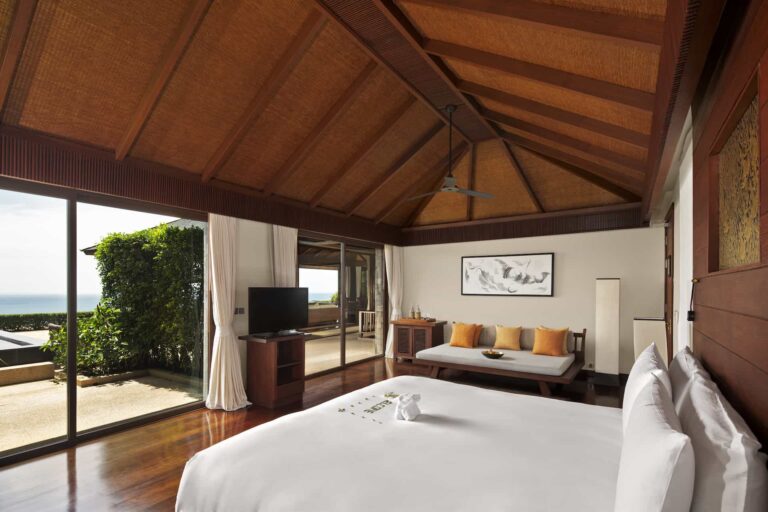 Grand Residence Pool Villa bedroom with access to balcony overlooking the water