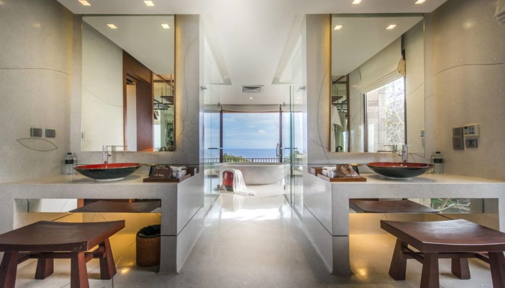 Freestanding bathtub next to a window with ocean view at Paresa Resort.