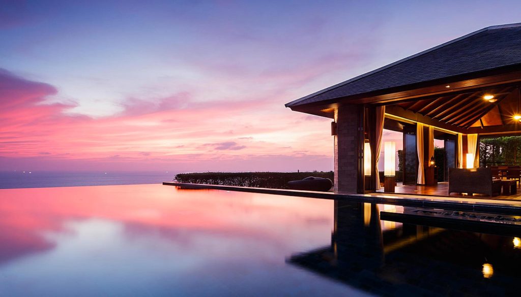 Paresa Resort infinity pool overlooking the ocean at sunset.