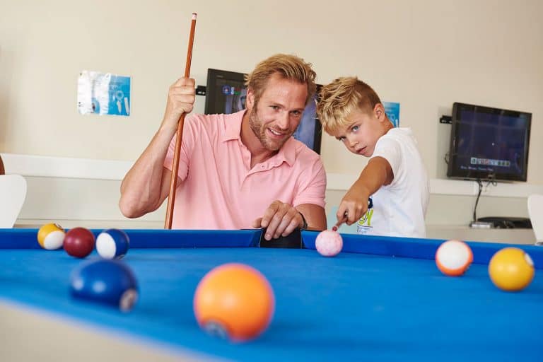 Father and son playing a game of pool