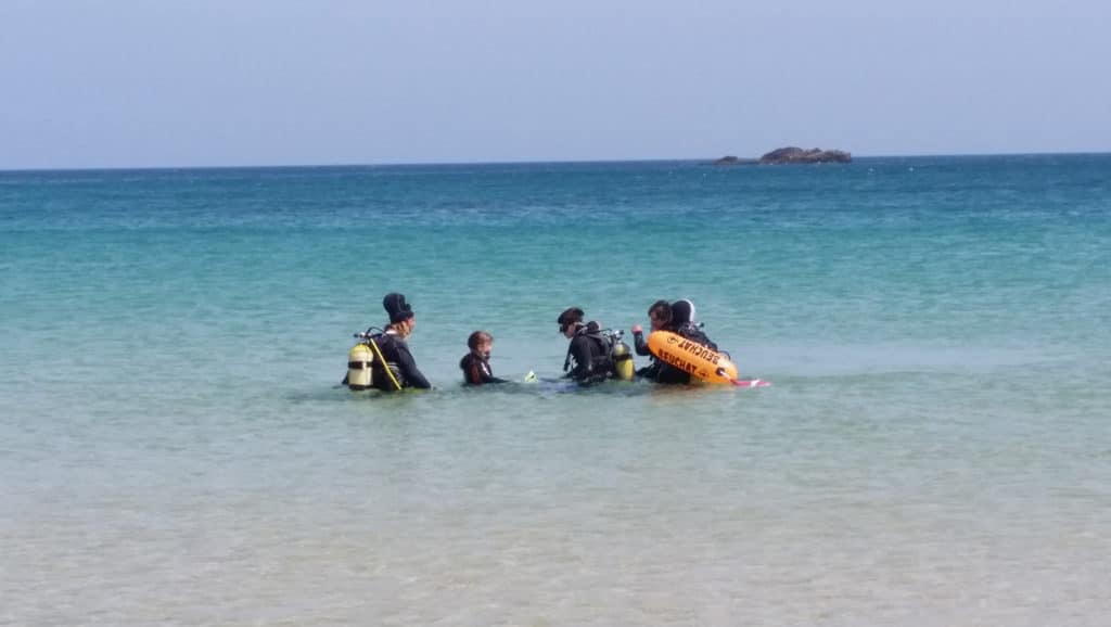 Family in scuba gear sitting in the water