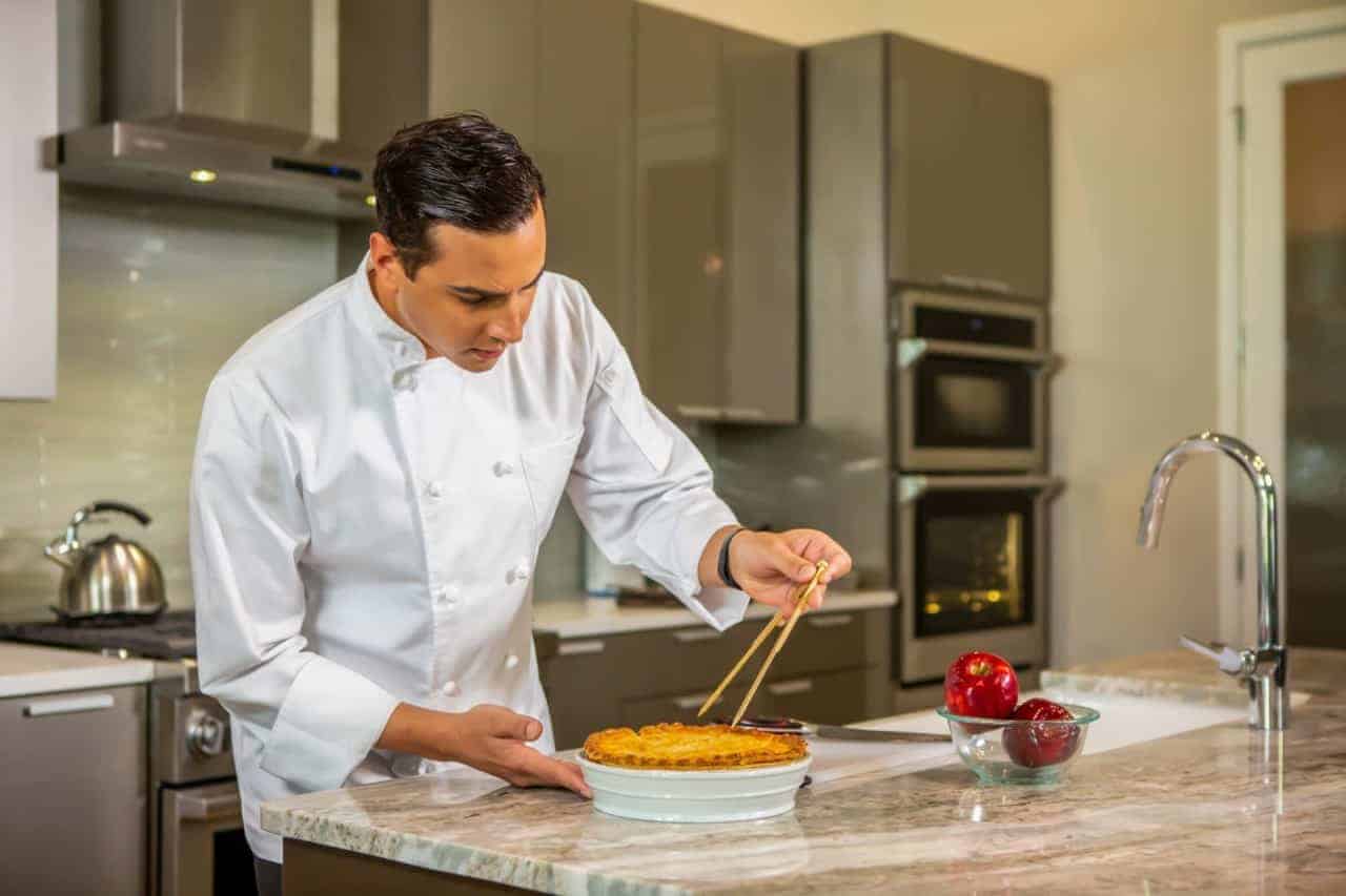 An expert chef prepares a meal during an at home chef experience.