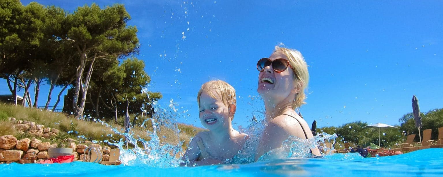 Mother and son splashing in a pool