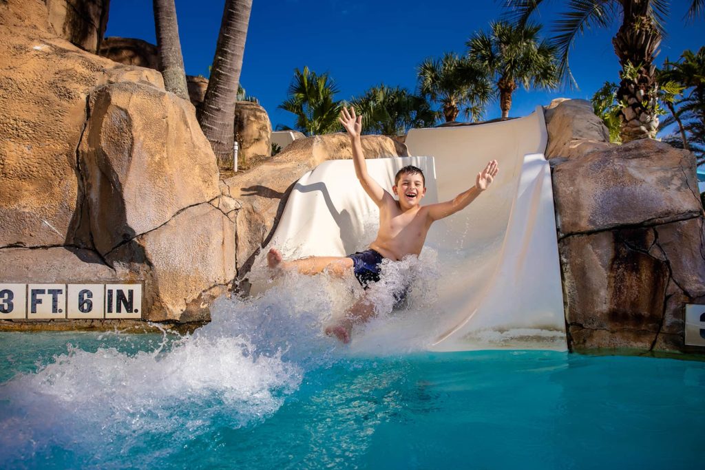 Happy kid on a water slide at a resort water park.