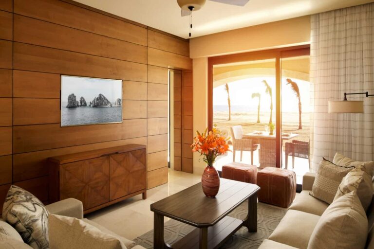 Sala de estar de la Grand Master Suite con sofás, TV empotrada en la pared y acceso al balcón