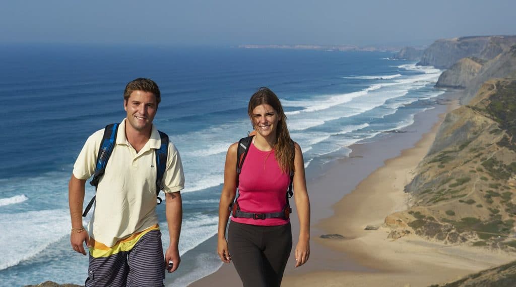 Couple on a hike walking by the ocean