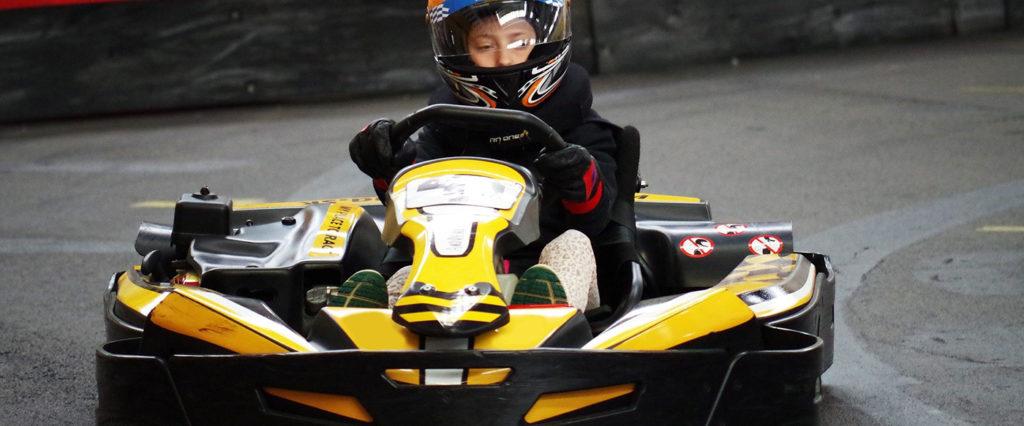 Kid driving a go kart on a track