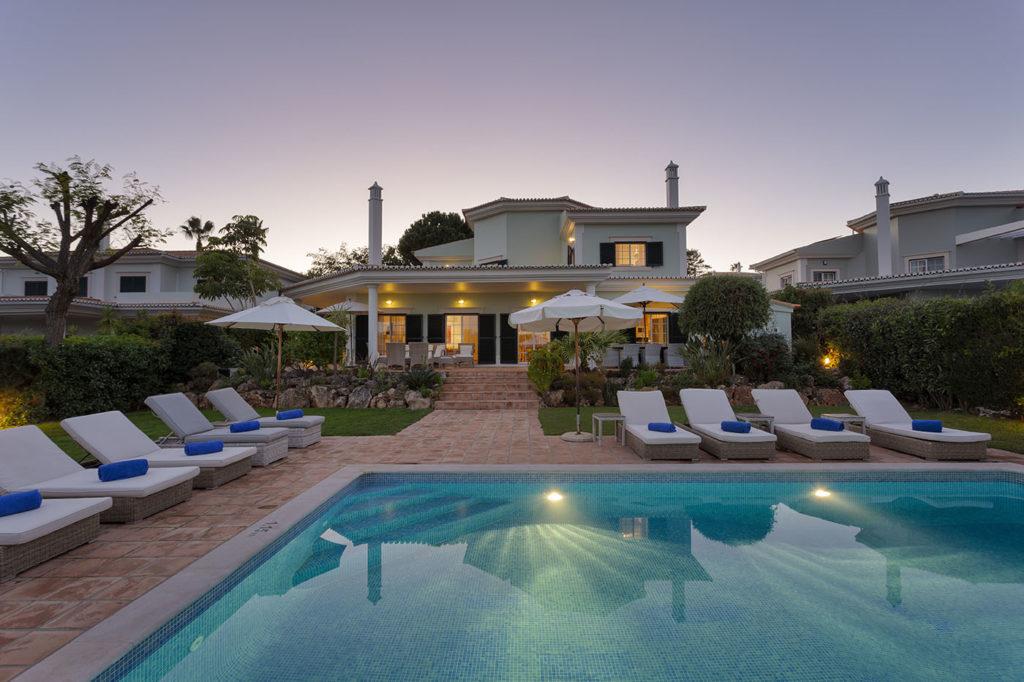 View of luxury villa backyard and pool at night