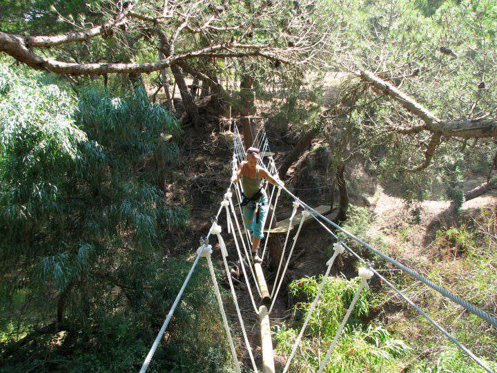 Woman crossing a bridge on a ropes course