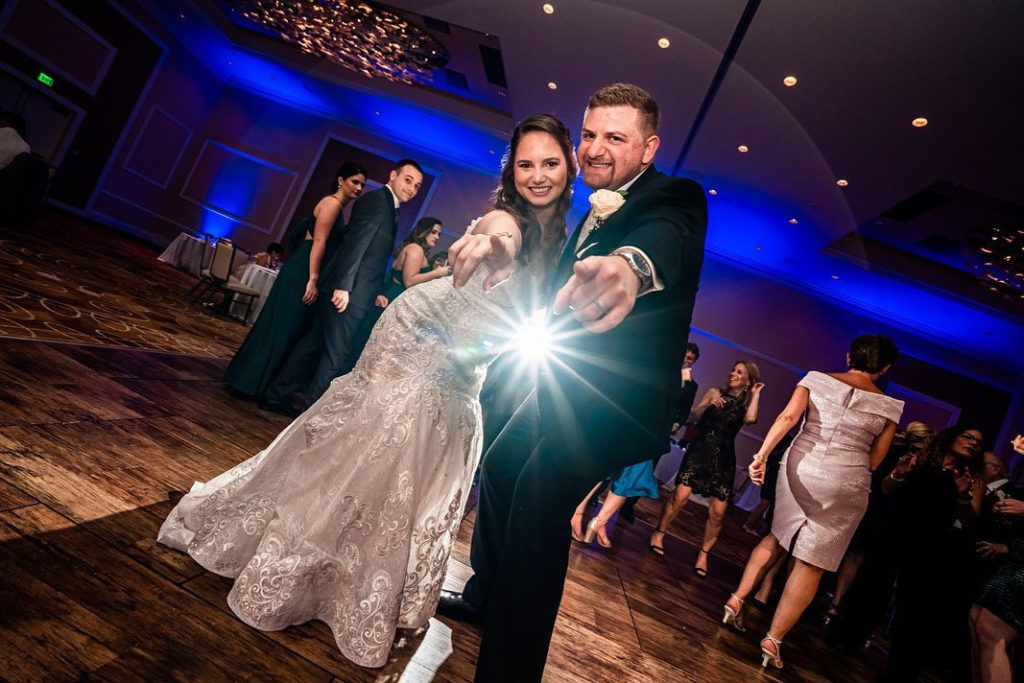 La novia y el novio bailan durante una alegre canción en la recepción de una boda.