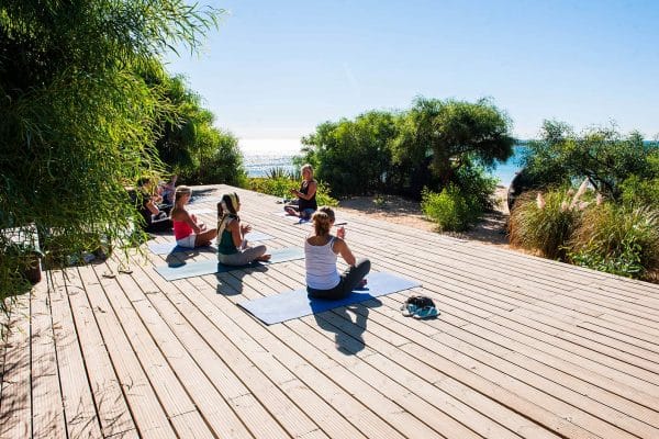 Group of people doing yoga on a deck
