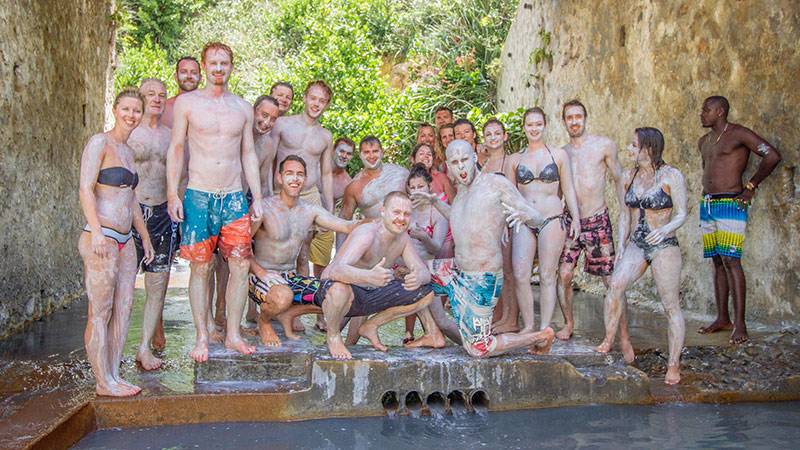 Group of people posing during a mud bath experience in St. Lucia.