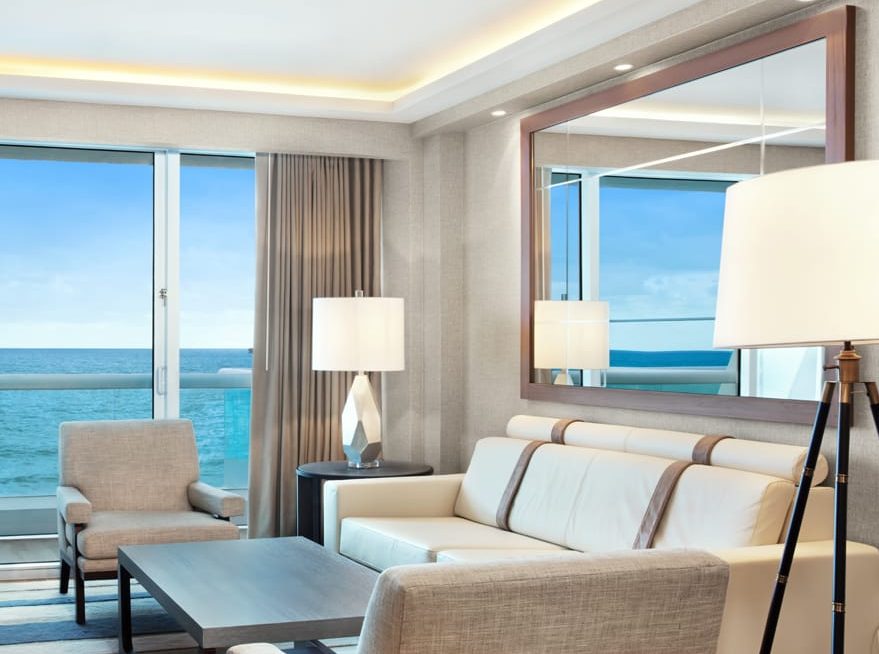 Sala de estar de la suite frente al mar con balcón en Conrad Fort Lauderdale Beach