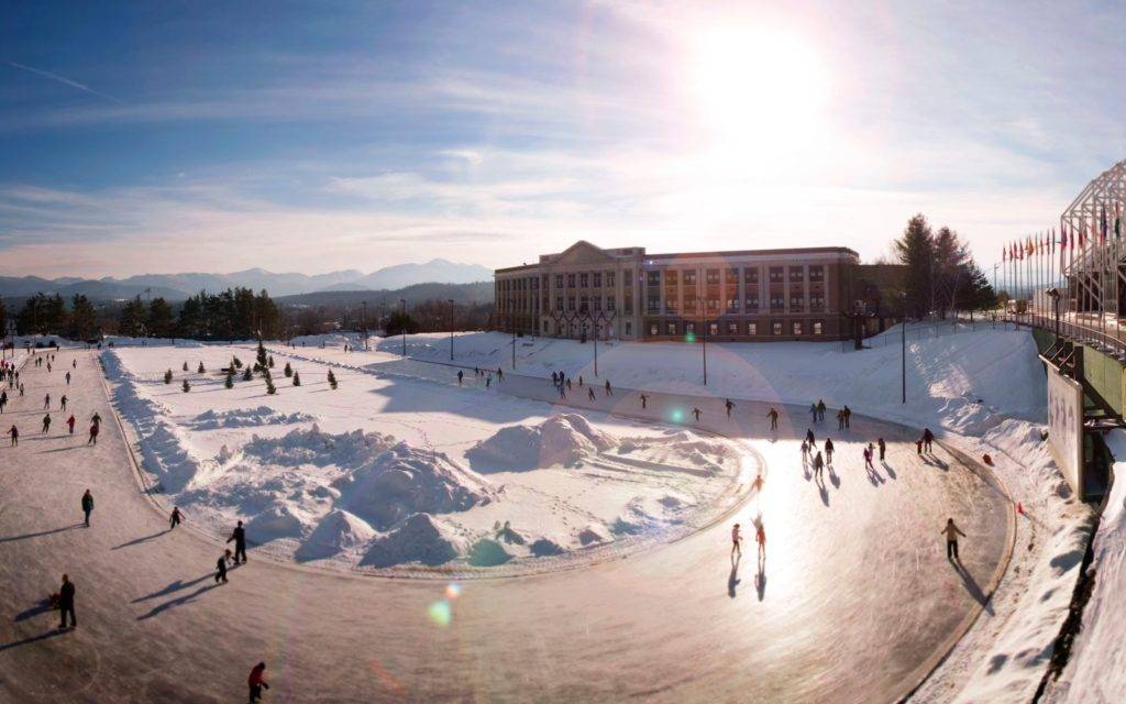 Bird's eye view of people ice skating in front of an Olympic venue in Lake Placid