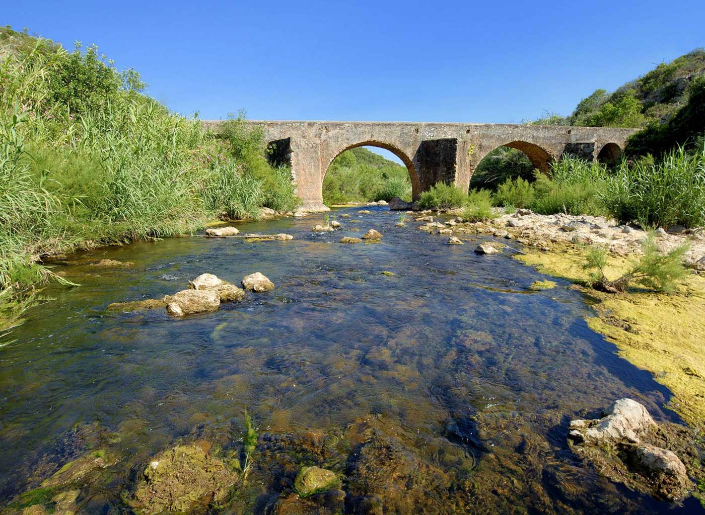Historical aqueduct crossing over a river in Algrave, Portugal