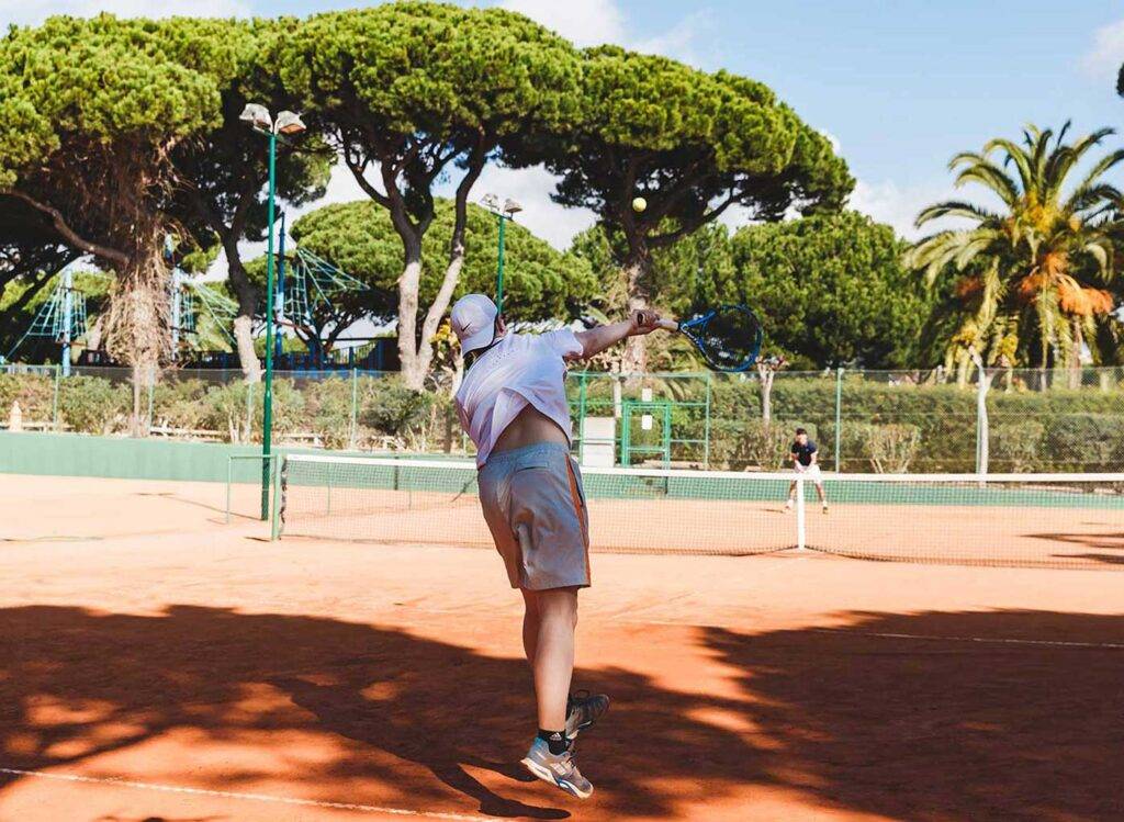 Men playing tennis on a clay court at the Pine Cliffs Resort